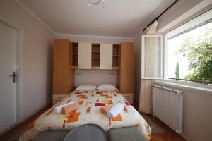 a bedroom with a bed and a large window at Double Room Banjol 5077b in Rab