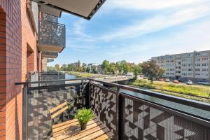 a balcony with a view of a river and buildings at Downtown Apartments Riverside Dwie Motławy in Gdańsk