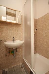 uma casa de banho com um lavatório e um chuveiro em Studio Tucepi 6857c em Tučepi