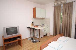 uma sala de estar com uma televisão e uma cozinha em Studio Makarska 6696a em Makarska