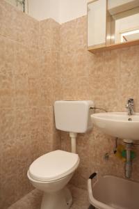 uma casa de banho com um WC e um lavatório em Studio Tucepi 6857c em Tučepi