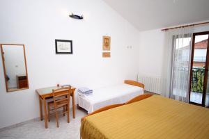 a bedroom with two beds and a table and a mirror at Triple Room Gornje selo 5170d in Grohote