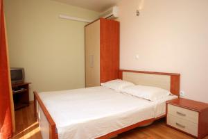 a small bedroom with a bed and a cabinet at Studio Duce 4852b in Duće