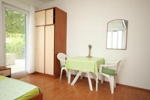Zimmer mit einem Tisch, Stühlen und einem Spiegel in der Unterkunft Studio Brela 6907b in Brela