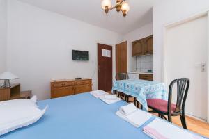 Habitación con 2 camas, mesa y cocina. en Studio Baska Voda 6773c, en Baška Voda