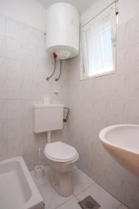 La salle de bains blanche est pourvue de toilettes et d'un lavabo. dans l'établissement Studio Podaca 6745c, à Podaca
