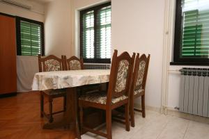 comedor con mesa, sillas y ventanas en Studio Turanj 6445b, en Turanj