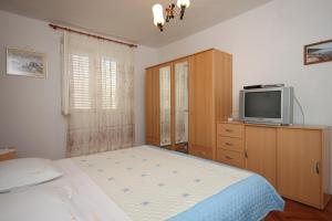 a bedroom with a bed and a tv on a dresser at Triple Room Sucuraj 6734c in Sućuraj
