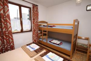 Cette chambre comprend 2 lits superposés et une table. dans l'établissement Triple Room Povljana 6476b, à Povljana
