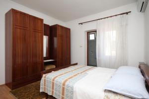 a bedroom with a large bed and wooden cabinets at Double Room Metajna 6496b in Metajna
