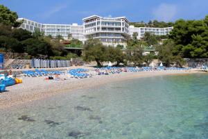 a beach with a bunch of chairs and a building at Double Room Hvar 15378a in Hvar
