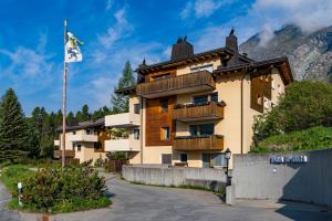 un edificio con una bandera delante de él en Pra d'Sura, en Maloja