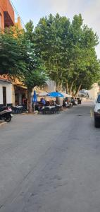 - un parking avec des tables, des parasols et des arbres dans l'établissement La Chirrichana 2, à Bicorp