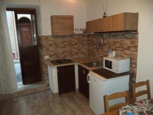 a small kitchen with a sink and a microwave at La Casuzza in Castellammare del Golfo