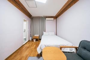 - une chambre avec un lit, un canapé et une chaise dans l'établissement Jeju Miju Hotel, à Jeju