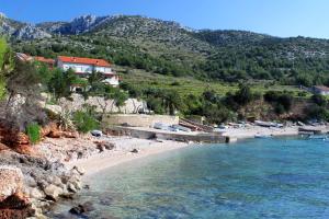 a beach with boats in the water and houses at Apartments and rooms with parking space Zavala, Hvar - 128 in Jelsa