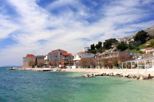 a beach in a town with houses and the water w obiekcie Apartments by the sea Suhi Potok, Omis - 11574 w mieście Jesenice