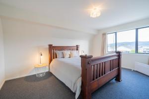 Un dormitorio con una cama grande y una ventana grande. en Acheron Homestead - Te Anau Holiday Home, en Te Anau