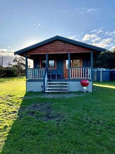 a small house with a red frisbee in front of it at Bretts Rest AZA in Kingscote