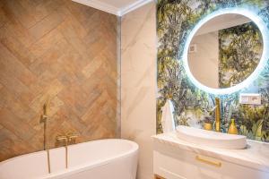 a bathroom with a tub and a sink and a mirror at Apartmány pod Zámkom in Bojnice +107 photos
