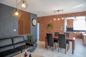 a living room with a table and chairs and a clock at Apartmány pod Zámkom in Bojnice