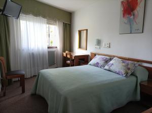 1 dormitorio con cama, mesa y ventana en Hostal Palas, en A Coruña