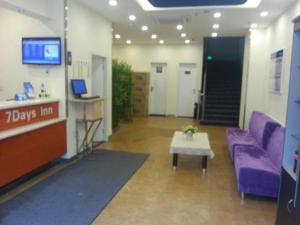 - un salon avec un canapé violet et une table dans l'établissement 7Days Inn Railway Station Wulukou Subway Station, à Xi'an