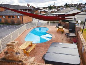 a backyard with a swimming pool and a hammock at Ben Chifley Motor Inn in Bathurst