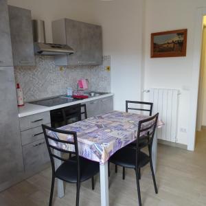 uma cozinha com uma mesa e cadeiras numa cozinha em Appartamento ROSA - Colori del Lago d'Orta - NUOVA STRUTTURA A OMEGNA em Omegna