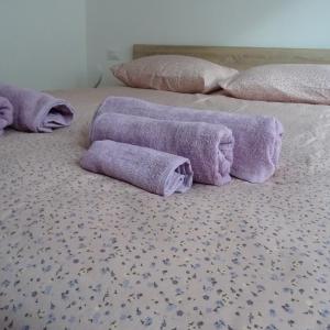 duas camas com toalhas roxas em cima em Appartamento ROSA - Colori del Lago d'Orta - NUOVA STRUTTURA A OMEGNA em Omegna
