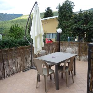 奧梅尼亞的住宿－Appartamento ROSA - Colori del Lago d'Orta - NUOVA STRUTTURA A OMEGNA，庭院里配有桌椅和遮阳伞