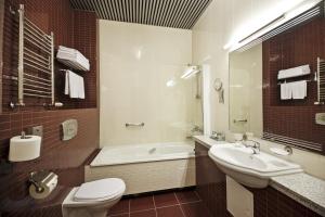 a bathroom with a tub and a sink and a toilet at Victoria Hotel & Business centre Minsk in Minsk