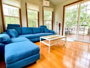 a living room with a blue couch and a table at Le Grand Bleu in Amami