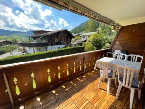 a balcony with a table and chairs and a view at Apartment Résidence Sonnegg - Reimers - Vogel in Zweisimmen