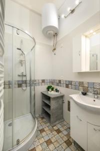 een witte badkamer met een douche en een wastafel bij JA18 Downtown Pearl - 2 bedroom apartment in Boedapest