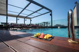 uma bandeja de frutas numa mesa ao lado de uma piscina em O Monot Boutique Hotel Beirut em Beirute