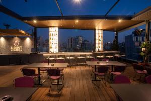 un patio en la azotea con mesas y sillas en un edificio en O Monot Boutique Hotel Beirut, en Beirut