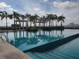 a large swimming pool with palm trees in a city at SKF Homestay in Puchong