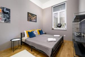 een slaapkamer met een bed met blauwe en gele kussens bij JA18 Downtown Pearl - 2 bedroom apartment in Boedapest