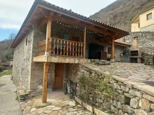 にあるCasa Rectoral de Montovo, casa rural en Red Natura 2000の石造りの家で、バルコニーが付いています。