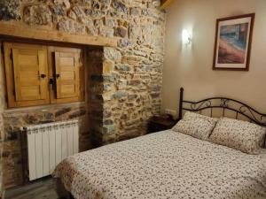にあるCasa Rectoral de Montovo, casa rural en Red Natura 2000の石壁のベッドルーム1室(ベッド1台付)