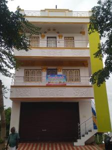 a man standing in front of a building with a garage at Guru Residency Pondicherry in Puducherry