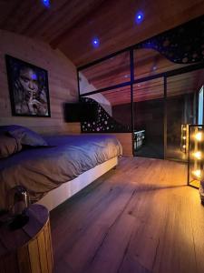 1 Schlafzimmer mit 2 Betten und Holzboden in der Unterkunft Les Fermes de Manat gîte romantique avec piscine balnéo et sauna 