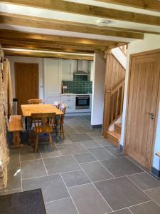 comedor con mesa y cocina en Cuddfan Fach - Pembrokeshire Stunning Barn near the Coastal Path en Abercastle