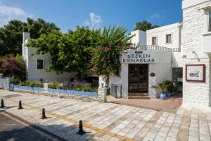 a building with a sign that reads seán komenei at Seckin Konaklar in Bodrum City