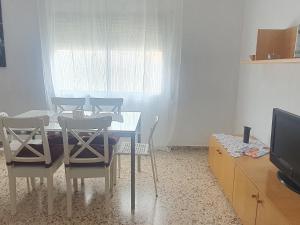 une salle à manger avec une table, des chaises et une télévision dans l'établissement La Chirrichana 2, à Bicorp