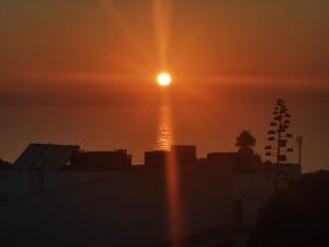 a sunset over the ocean with the sun in the sky at Amazing Lodge by the Ocean - Fully equipped! in Ericeira