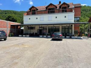 a car parked in a parking lot in front of a building at Restaurant - Rooms "Pače 027" Restoran - Prenociste in Kuršumlija