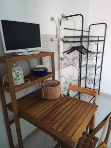 Zimmer mit einem Holztisch und einem TV auf dem Schreibtisch in der Unterkunft Stella Maris in Conversano