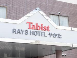 a sign for a hotel in front of a building at Tabist Rays Hotel Yakata in Miyazaki